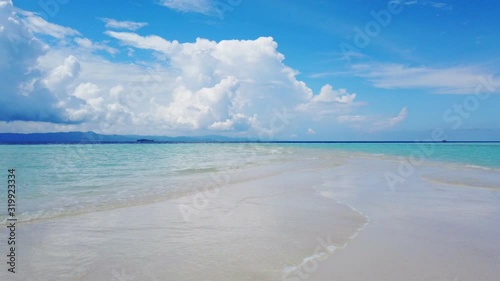 Sandbar left by receding tide with blue sky, seascape in summer time.