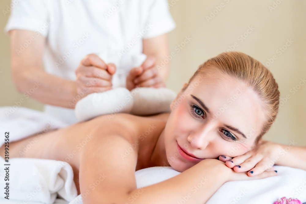 Beautiful young attractive Caucasian woman having body massage by Thai Masseur in spa salon. Beauty treatment and body care lifestyle concept
