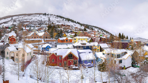 Panorama frame Colorful homes and scenic hills blanketed with white snow during winter season