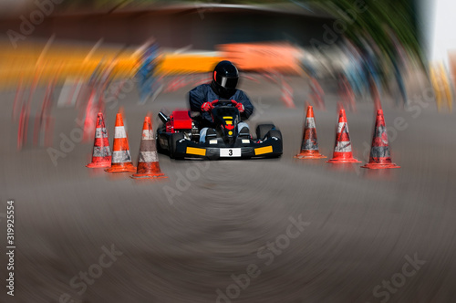 Go Cart Rennen mit Fahrer in Sicherheitsbekleidung rasend auf dem Streckenverlauf © Argus