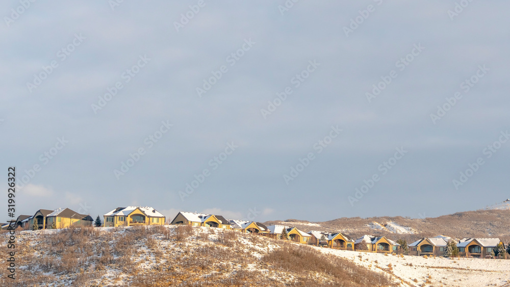 Panorama Houses on neighborhood nestled on top of snowy hills viewed in winter