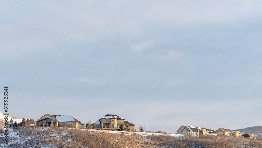 Obraz premium Panorama Houses on top of hill with panoramic view of snowy terrain and natural beauty