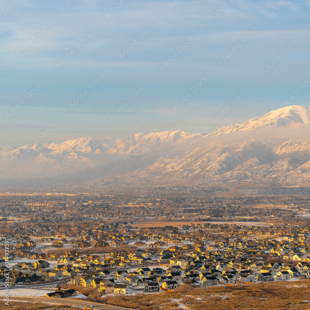Square frame Mount Timpanogos and residential neighborhood with winter snow at sunset