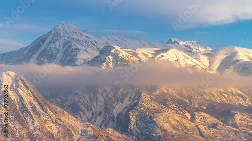 Photo Panorama frame Snowy Mount Timpanogos and charming homes against cloudy blue sky at sunset