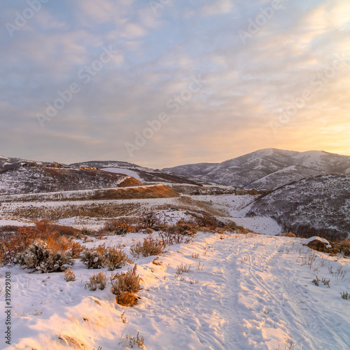 Photo Square frame Hill landscape blanketed with snow and illuminated by sunlight at sunset