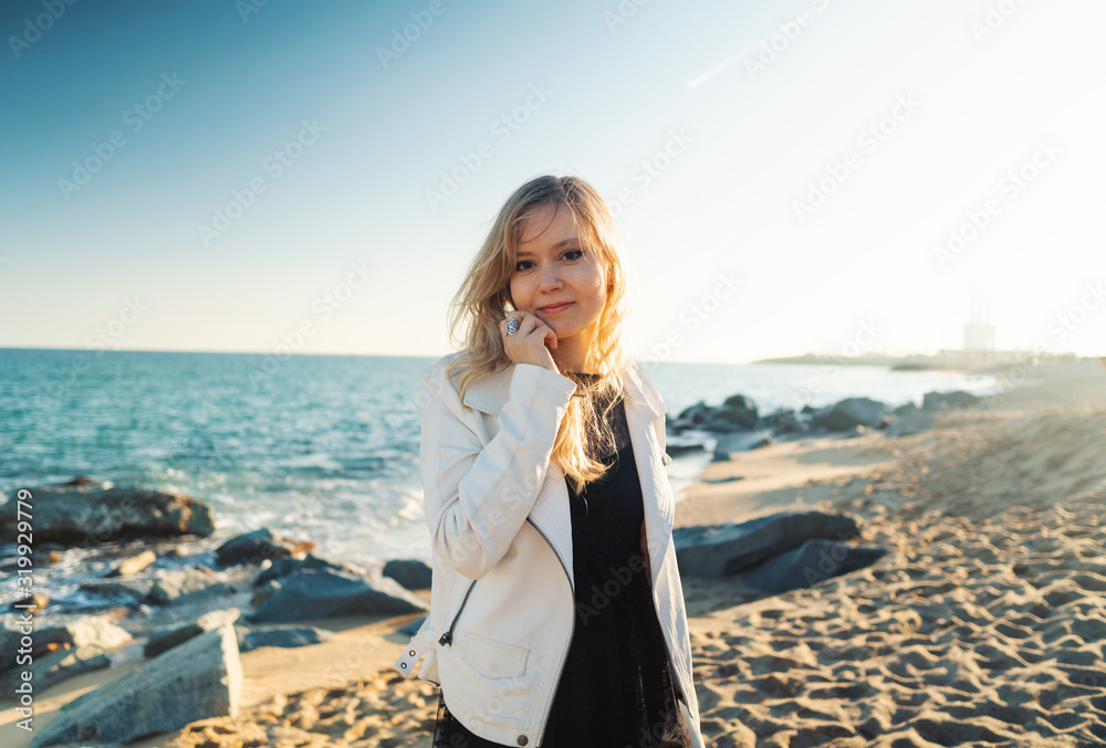 Young woman walking at beautiful ocean beach on sunset. The concept of relaxation, happiness and freedom. Young woman walking at beautiful ocean beach on sunset. The concept of relaxation, happiness and freedom.