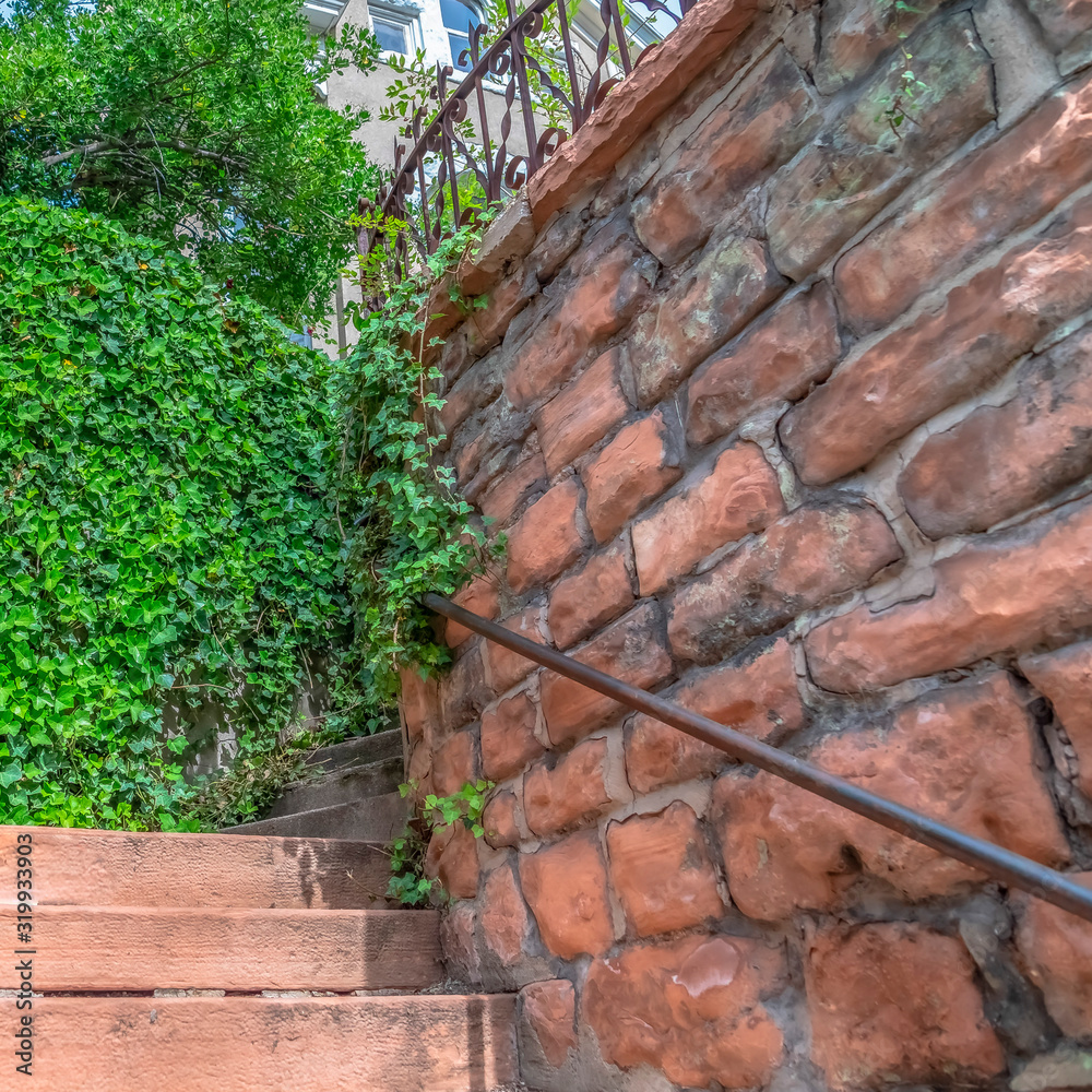 Square frame Close up of outdoor stairs amid stone brick retaining walls that leads to a home Square frame Close up of outdoor stairs amid stone brick retaining walls that leads to a home