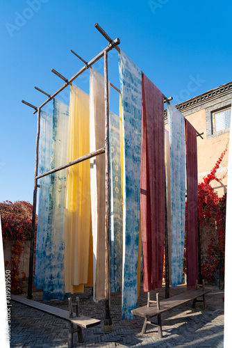 Yongshun Dyeing Workshop, Beijing Wtown（Gubei Water Town）, China. Colorful cloths hanging to dry in the yard. photo