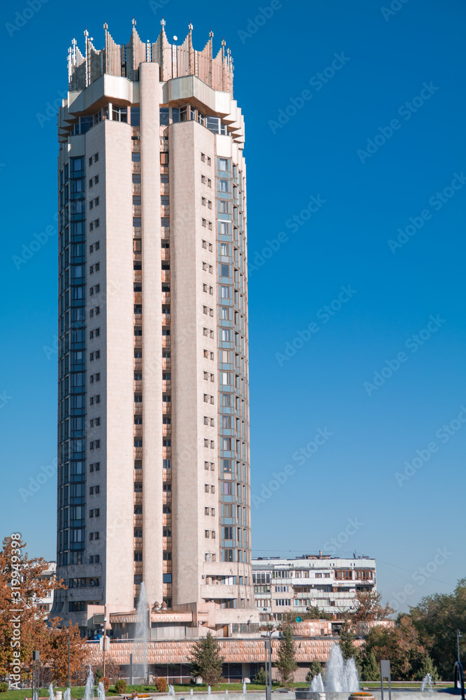 Tall building with crown hotel Kazakhstan against the vivid blue sky in Almaty