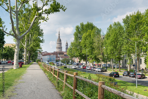 Street in Novara city, Italy, near the public park and the castle of Novara. Largo Bellini with the dome of the basilica of San Gaudenzio (16th - 19th century)