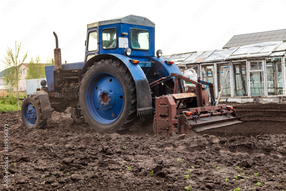 A tractor plows the land on nature A tractor plows the land on nature