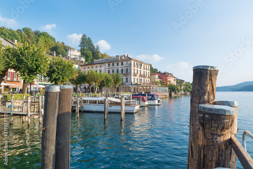 Lake Orta and the scenic village of Orta San Giulio, Italy. Jetties and boats on the lakefront in front of Piazza Motta (square Motta), located in the historic center of the town photo