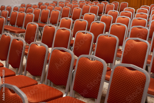 empty rows of comfortable soft orange chairs, a hall for meetings, conferences, events, seminars, study, work