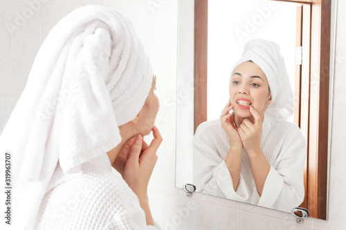 gorgeous beauty brunette checking her teeth in front of a mirror in bathroom. self hygiene everyday routine.