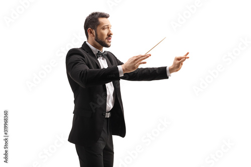 Male conductor in a suit conducting with a baton and gesturing with hand photo