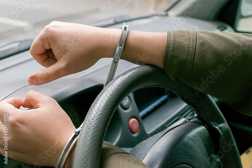 Obraz na plátně car driver hands handcuffed to the steering wheel, arrest, driving ban by traffi