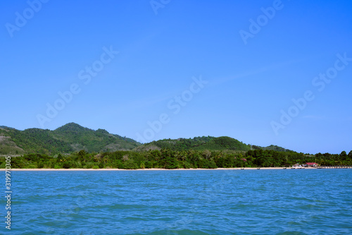A shot of a beach in the distance over the water. © adibella6370