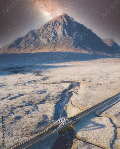 Buachaille Etive Mor aerial view at night during winter frost moor with stars in sky highlands landscape and A82 road bridge at Glencoe Scotland photo