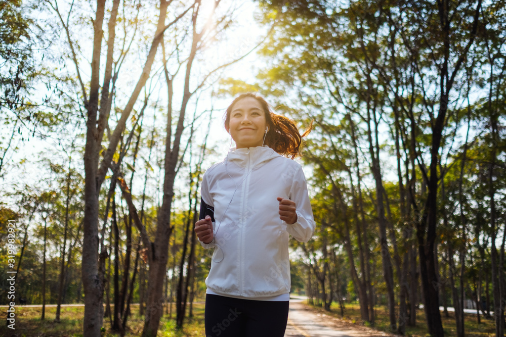 A young asian woman jogging in city park in the morning A young asian woman jogging in city park in the morning