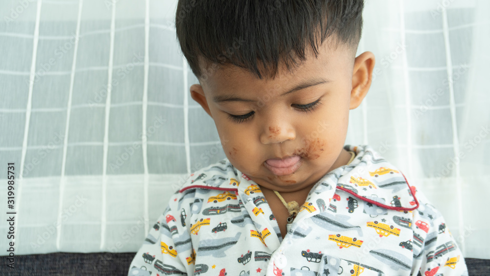 Cute little asian baby boy eatting chocolate Cute little asian baby boy eatting chocolate