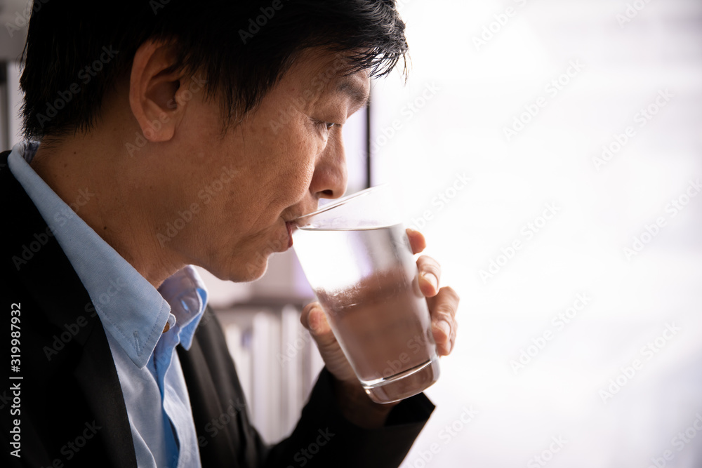 . Man drinking a cold water in glass portrait with copy space. . Man drinking a cold water in glass portrait with copy space.