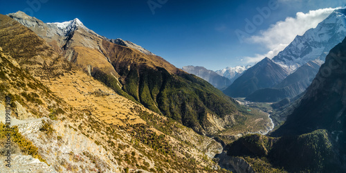Panoramic view of the Marshyangdi river valley with Ghyaru and Pisang villages, Pisang peak and Mt. Annapurna II. Annapurna circuit trek, Nepal. photo