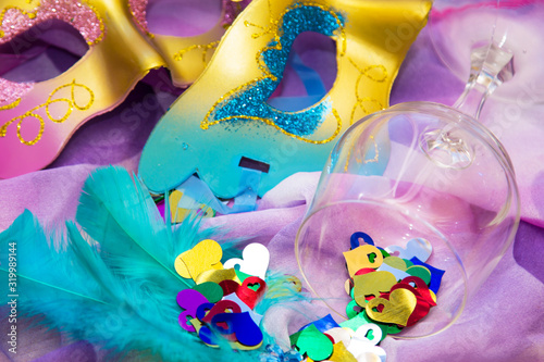 glass cup full of confetti and carnival masks, happy carnival