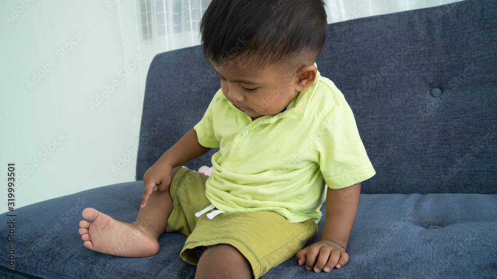 Fototapeta premium Cute little boy looking foot