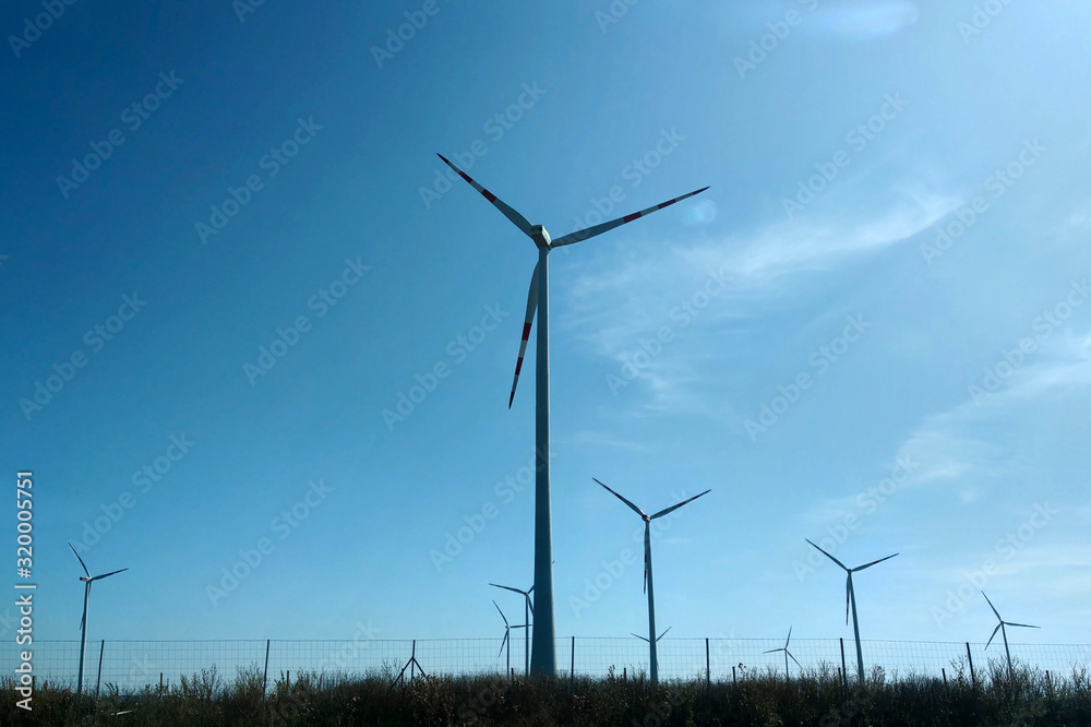 Wind turbine on the green grass over the blue sky. Wind turbine on the green grass over the blue sky.