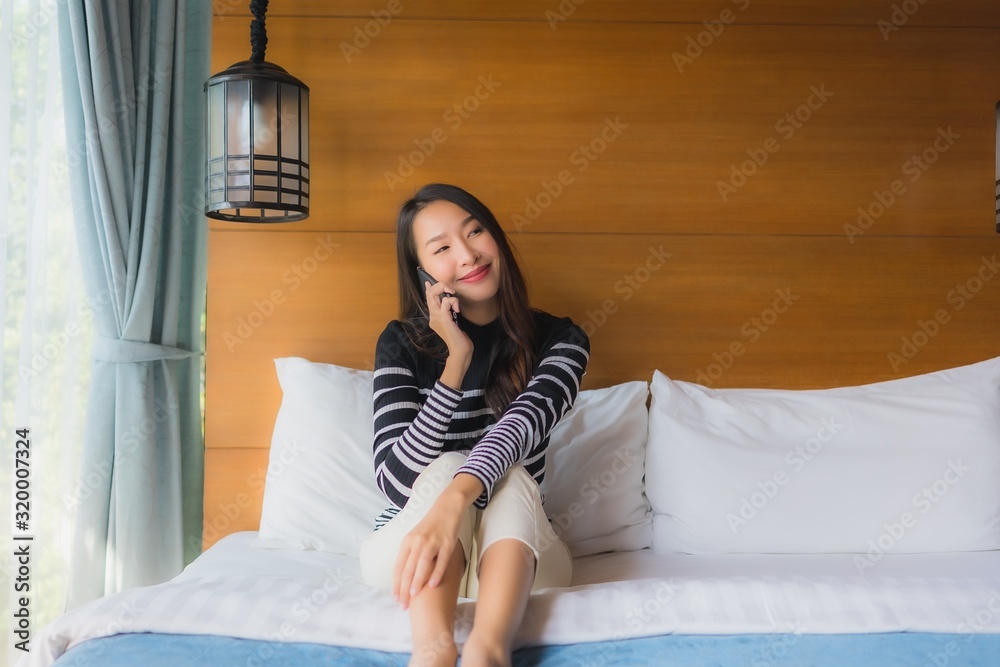 Portrait young asian woman using smart mobile phone on bed in bedroom Portrait young asian woman using smart mobile phone on bed in bedroom