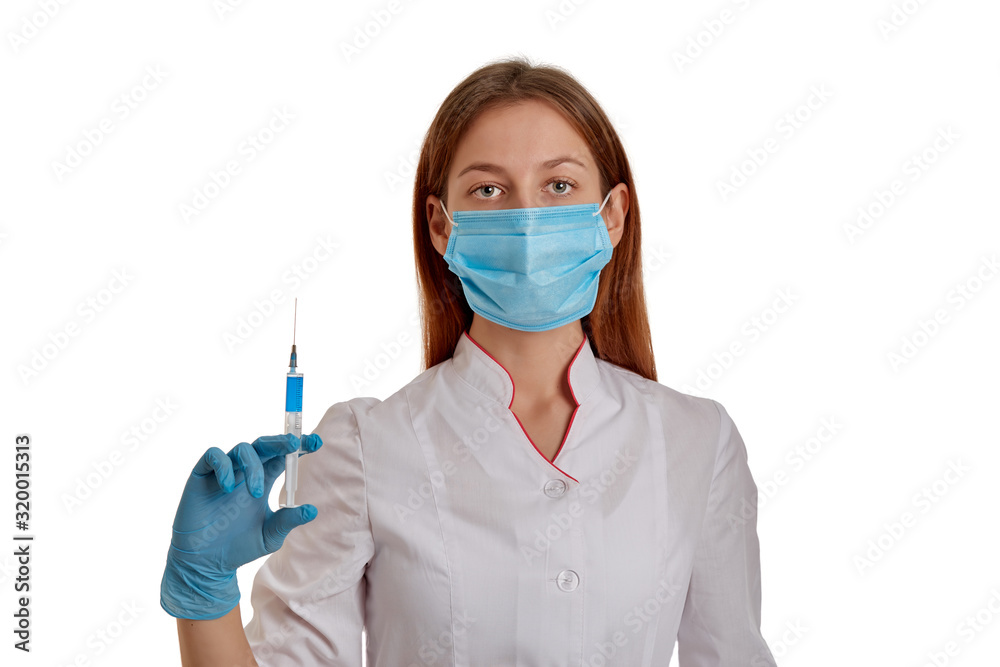 The doctor is holding a syringe with medicine for coronavirus 2019-nCoV. A nurse in a respiratory mask protects herself from a new rapidly spreading coronavirus from China. The doctor is holding a syringe with medicine for coronavirus 2019-nCoV. A nurse in a respiratory mask protects herself from a new rapidly spreading coronavirus from China.