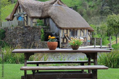 A table and vases in front of an old cottage