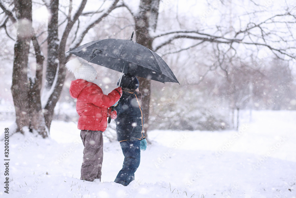 Kids walk in the park first snow Kids walk in the park first snow