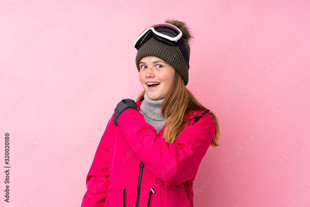 Ukrainian teenager skier girl with snowboarding glasses over isolated pink background celebrating a victory Ukrainian teenager skier girl with snowboarding glasses over isolated pink background celebrating a victory