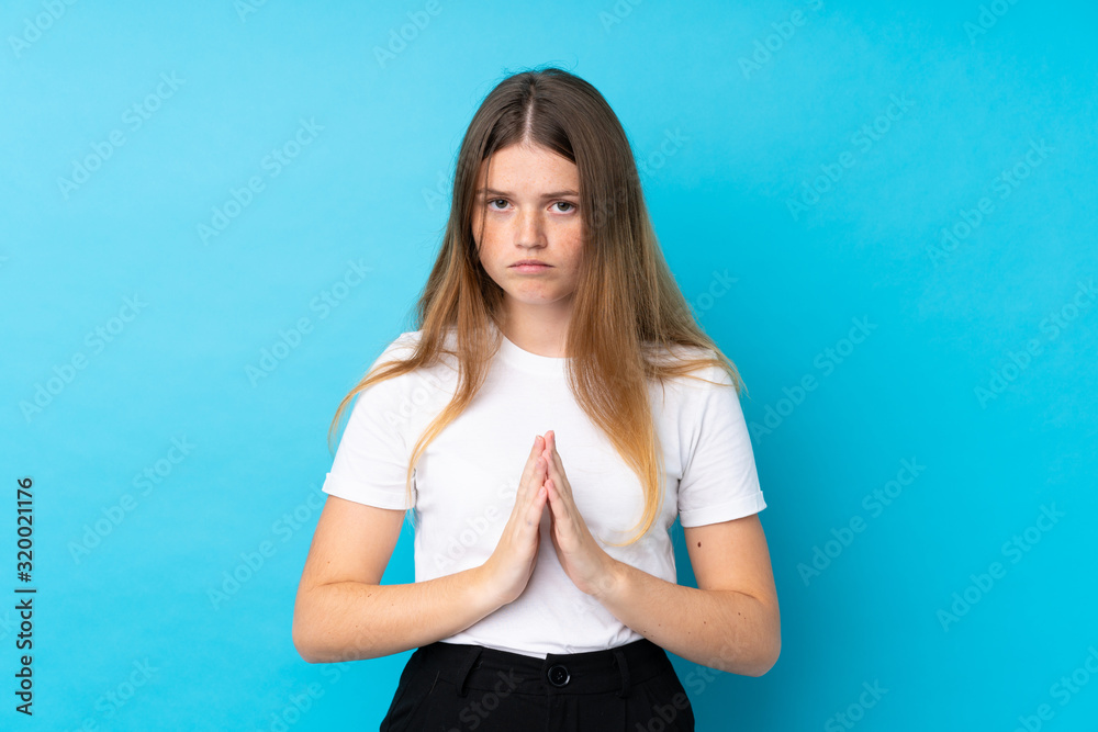 Ukrainian teenager girl over isolated blue background pleading Ukrainian teenager girl over isolated blue background pleading