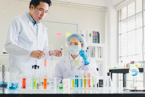 Asian scientists  men and women are helping to test and analyze various color chemicals in laboratories that have many scientific equipment.