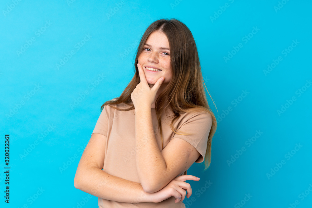 Ukrainian teenager girl over isolated blue background smiling