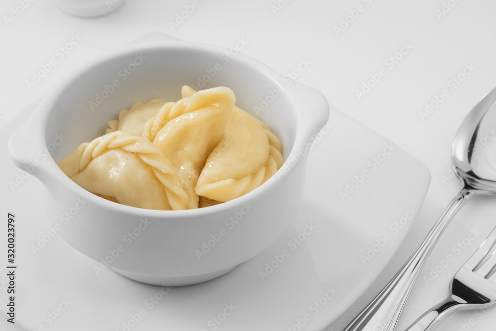 close up view of plate with dumplings  on white background.