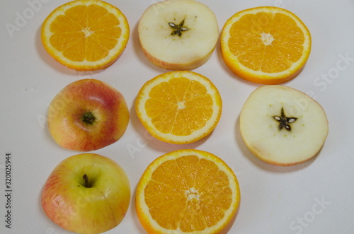 On a white background delicious sliced       fruits  apples and oranges.