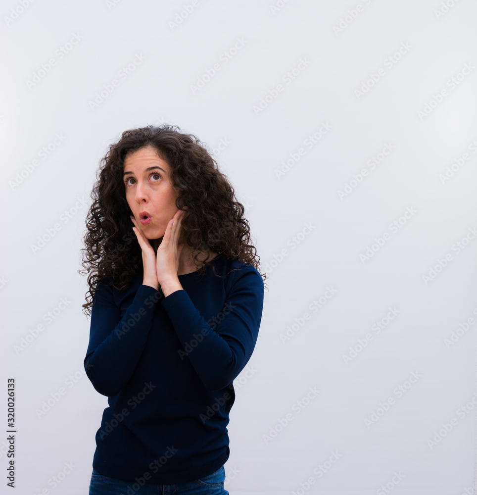 young pretty woman with black curly hair against white wall young pretty woman with black curly hair against white wall