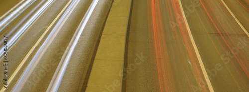 Long exposure photography of traffic on the city street. Road if filled out by cars. Rush hours. Right geometrical forms concepts. Soft pastel colors and background. High angle view / top view. 