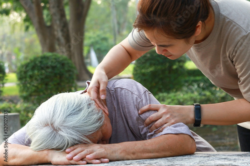 Fotografie Sick asian senior woman fainted unconscious at the table, fall face down,elderly female patient stop breathing due to heart failure, cardiac arrest,severe arrhythmia, sudden unexpected death syndrome