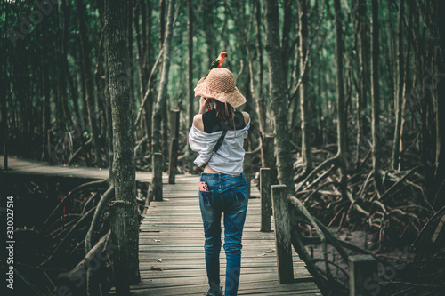 A woman and a parrot in the forest