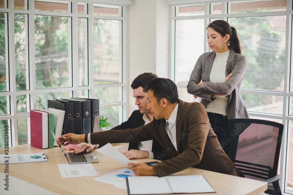 Businessmen are looking at the business plan and business results from the notebook in the office. Businessmen are looking at the business plan and business results from the notebook in the office.