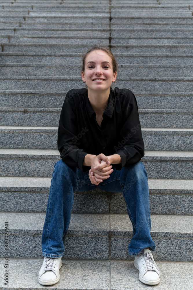 Young Woman Sitting on Outdoor Steps Smiling at Camera Young Woman Sitting on Outdoor Steps Smiling at Camera