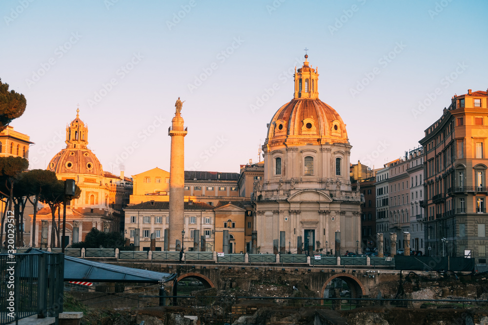 Obraz premium Rome, Italy - Jan 2, 2020: Trajan's Column (UNESCO World Heritage Site) in Trajan's Forum and church of Santa Maria di Loreto, Rome, Lazio, Italy
