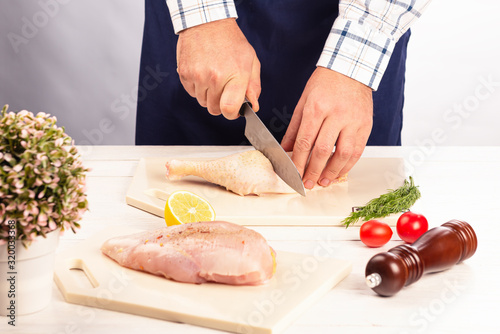 Cooking a dish of chicken meat on a cutting kitchen board made of artificial stone