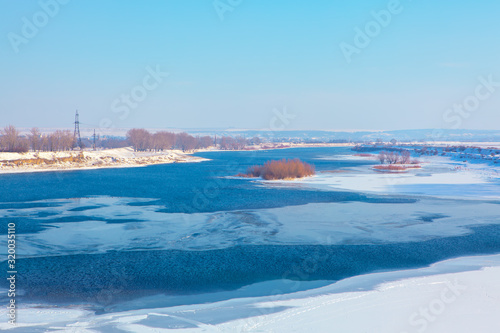 idyllic winter scenery with melting ice on the river