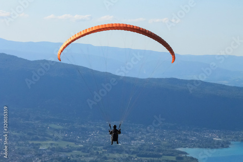 A man in a special suit paraglides over Lake Annecy, Savoy, France. Extreme sport