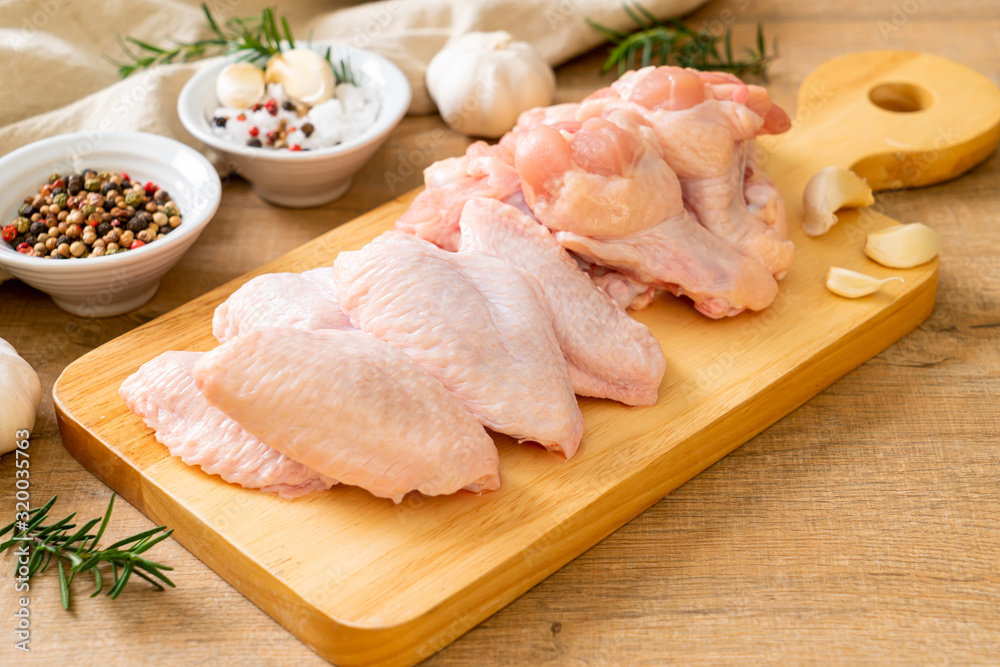 fresh raw chicken wings on wooden board
